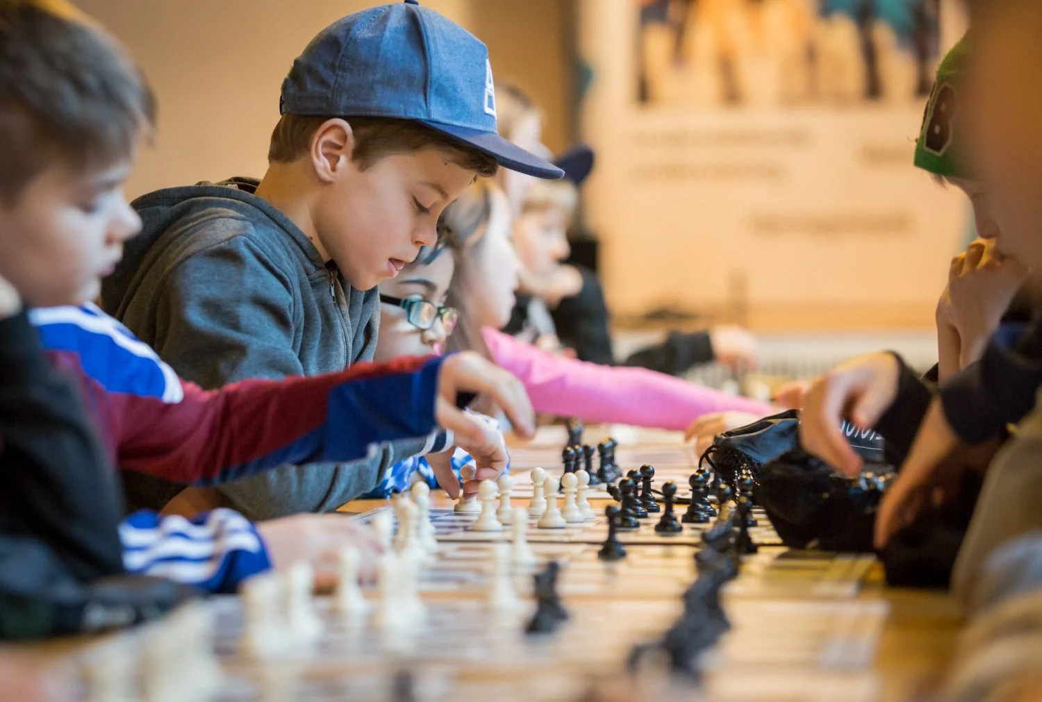 Elever spelar skolschack tillsammans och koncentrerar sig på brädet.